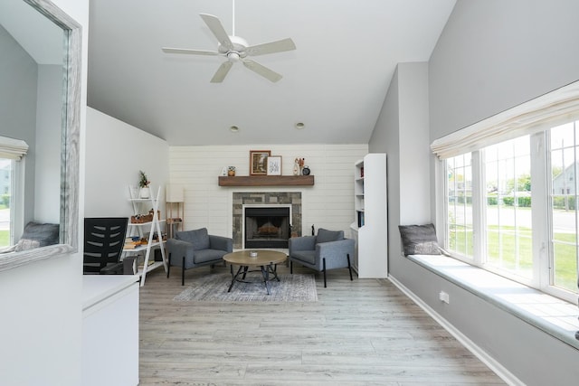 413 W Cook St, Manteno, IL 60950 - living area featuring healthy amount of natural light, lofted ceiling, light wood-type flooring, a stone fireplace, and a ceiling fan