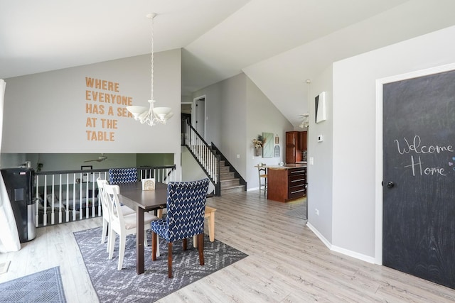 413 W Cook St, Manteno, IL 60950 - dining space featuring a chandelier, lofted ceiling, light wood-type flooring, stairway, and baseboards
