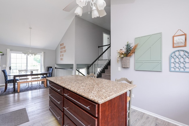 413 W Cook St, Manteno, IL 60950 - kitchen with dark brown cabinets, high vaulted ceiling, light wood finished floors, a kitchen island, and a ceiling fan