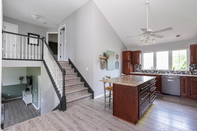 413 W Cook St, Manteno, IL 60950 - kitchen featuring dishwasher, light wood-style floors, a ceiling fan, a breakfast bar area, and vaulted ceiling