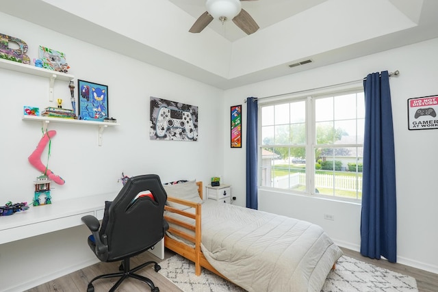 413 W Cook St, Manteno, IL 60950 - bedroom featuring wood finished floors, a tray ceiling, ceiling fan, a desk, and baseboards