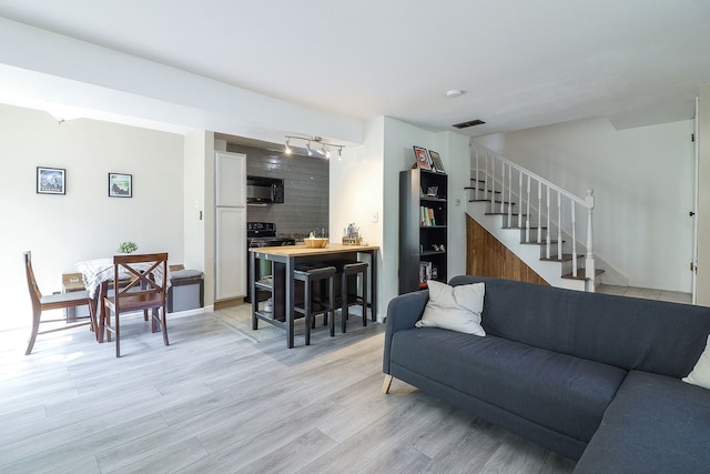 21 Fernwood Dr Unit 21U, Bolingbrook, IL 60440 - living room with stairs, light wood-style flooring, and rail lighting