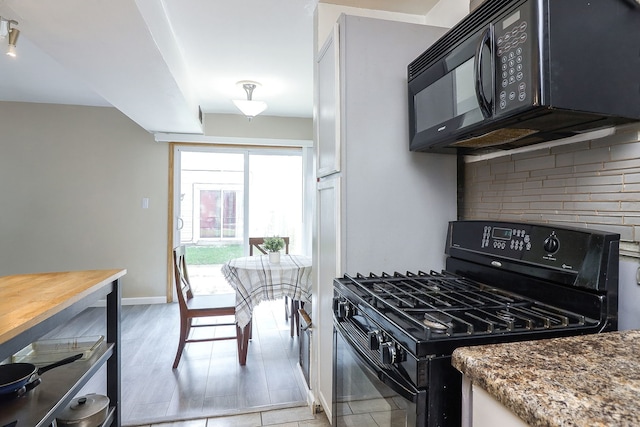 21 Fernwood Dr Unit 21U, Bolingbrook, IL 60440 - kitchen featuring black appliances, decorative backsplash, baseboards, and stone countertops