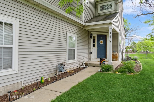 221 Wedgewood Cir, Lake In The Hills, IL 60156 - view of exterior entry featuring a lawn and roof with shingles
