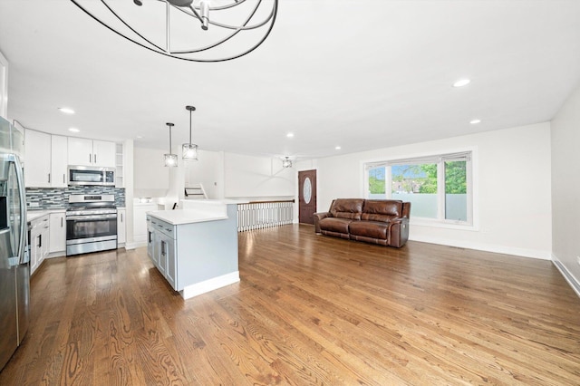 8300 S 79th Ct, Justice, IL 60458 - kitchen featuring appliances with stainless steel finishes, light countertops, recessed lighting, tasteful backsplash, and wood finished floors