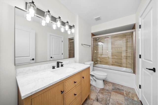 8300 S 79th Ct, Justice, IL 60458 - bathroom featuring toilet, vanity, stone finish floors, and combined bath / shower with glass door