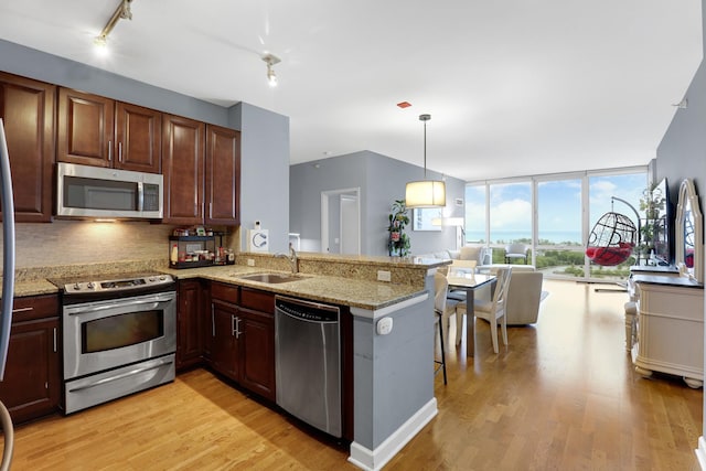 1629 S Prairie Ave Unit 1503, Chicago, IL 60616 - kitchen featuring stainless steel appliances, a sink, light wood-style flooring, open floor plan, and floor to ceiling windows