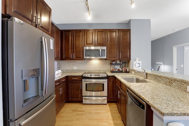 1629 S Prairie Ave Unit 1503, Chicago, IL 60616 - kitchen with stainless steel appliances, a sink, light wood-style flooring, a peninsula, and backsplash