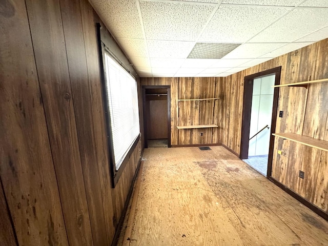 116 W 13th St, Kewanee, IL 61443 - empty room featuring wooden walls, a paneled ceiling, and baseboards