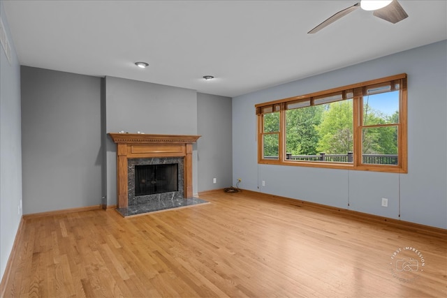 10N738 Prairie Xing, Elgin, IL 60124 - unfurnished living room with light wood-style floors, a ceiling fan, a premium fireplace, and baseboards