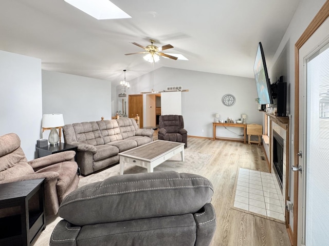 223 W Anderes Cir, Dalzell, IL 61320 - living room featuring vaulted ceiling, wood finished floors, a skylight, a fireplace with flush hearth, and a ceiling fan