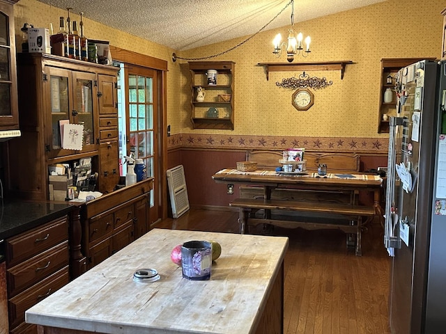 9669 Garden Plain Rd, Morrison, IL 61270 - dining space with wainscoting, wallpapered walls, vaulted ceiling, wood finished floors, and a textured ceiling