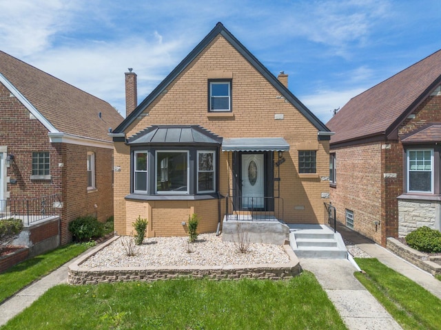 2702 N 76th Ave, Elmwood Park, IL 60707 - view of front of house featuring a chimney, brick siding, and a standing seam roof