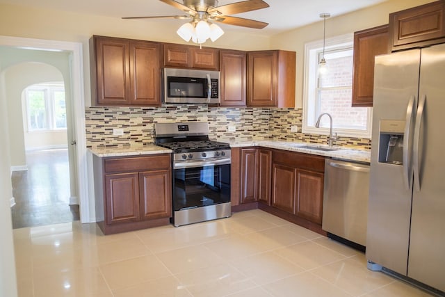 2702 N 76th Ave, Elmwood Park, IL 60707 - kitchen featuring stainless steel appliances, a sink, arched walkways, decorative backsplash, and a ceiling fan