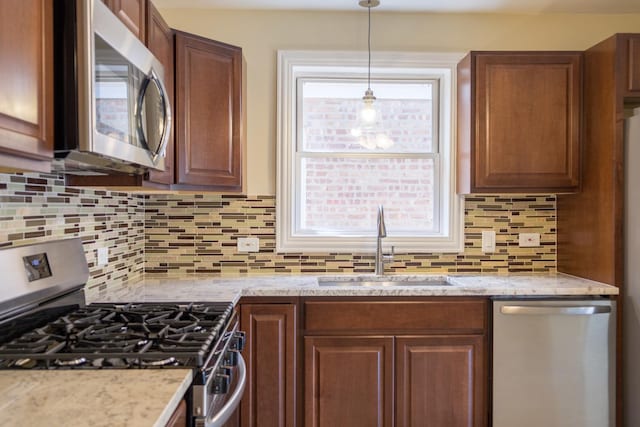 2702 N 76th Ave, Elmwood Park, IL 60707 - kitchen featuring appliances with stainless steel finishes, a sink, tasteful backsplash, light stone counters, and decorative light fixtures