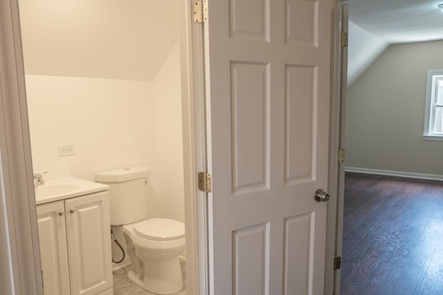 2702 N 76th Ave, Elmwood Park, IL 60707 - half bath featuring vaulted ceiling, toilet, vanity, wood finished floors, and baseboards