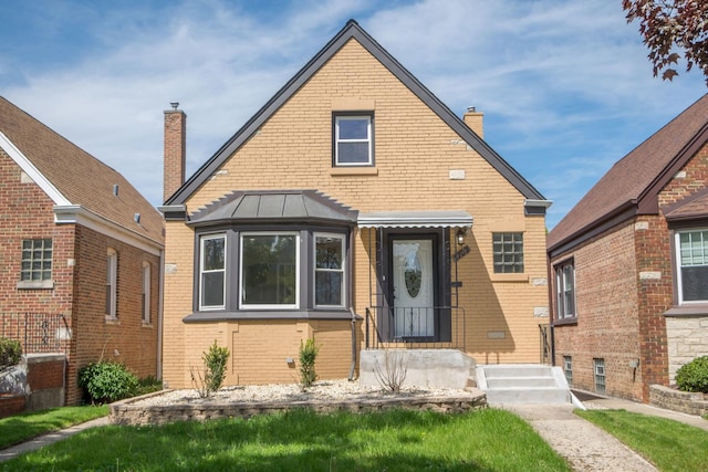 2702 N 76th Ave, Elmwood Park, IL 60707 - view of front of house featuring brick siding, a chimney, and a standing seam roof