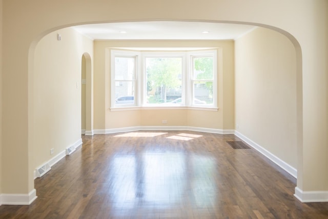 2702 N 76th Ave, Elmwood Park, IL 60707 - empty room with dark wood finished floors, arched walkways, and baseboards