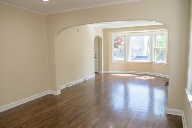 2702 N 76th Ave, Elmwood Park, IL 60707 - empty room featuring arched walkways, dark wood finished floors, baseboards, and ornamental molding