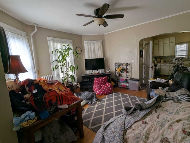 1215 3rd St, Moline, IL 61265 - bedroom featuring wood finished floors, multiple windows, crown molding, a ceiling fan, and arched walkways