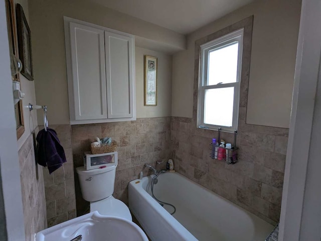1215 3rd St, Moline, IL 61265 - bathroom with tile walls, a garden tub, toilet, a wainscoted wall, and a sink