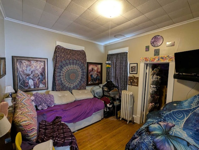 1215 3rd St, Moline, IL 61265 - bedroom featuring radiator heating unit, wood finished floors, and ornamental molding