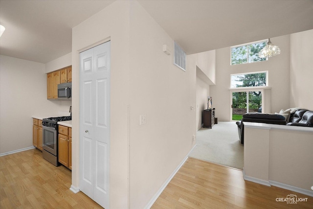 937 Huntington Dr, Elk Grove Village, IL 60007 - kitchen featuring stainless steel appliances, light wood finished floors, open floor plan, light countertops, and baseboards