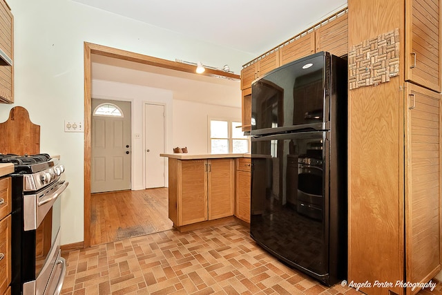 5704 N Woodland Dr, Mchenry, IL 60050 - kitchen featuring stainless steel range with gas cooktop, a peninsula, brick patterned flooring, and oven
