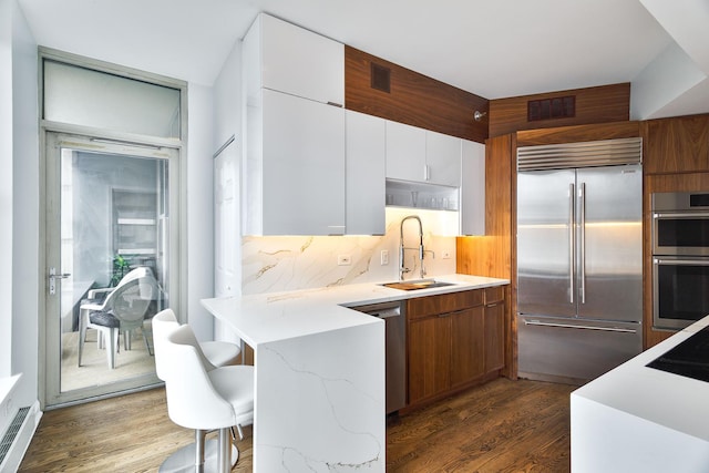 25 E Superior St Unit 2805, Chicago, IL 60611 - kitchen with stainless steel appliances, a sink, dark wood-style floors, a breakfast bar, and modern cabinets