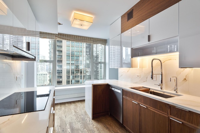 25 E Superior St Unit 2805, Chicago, IL 60611 - kitchen featuring stainless steel dishwasher, a sink, wood finished floors, black electric cooktop, and light stone counters