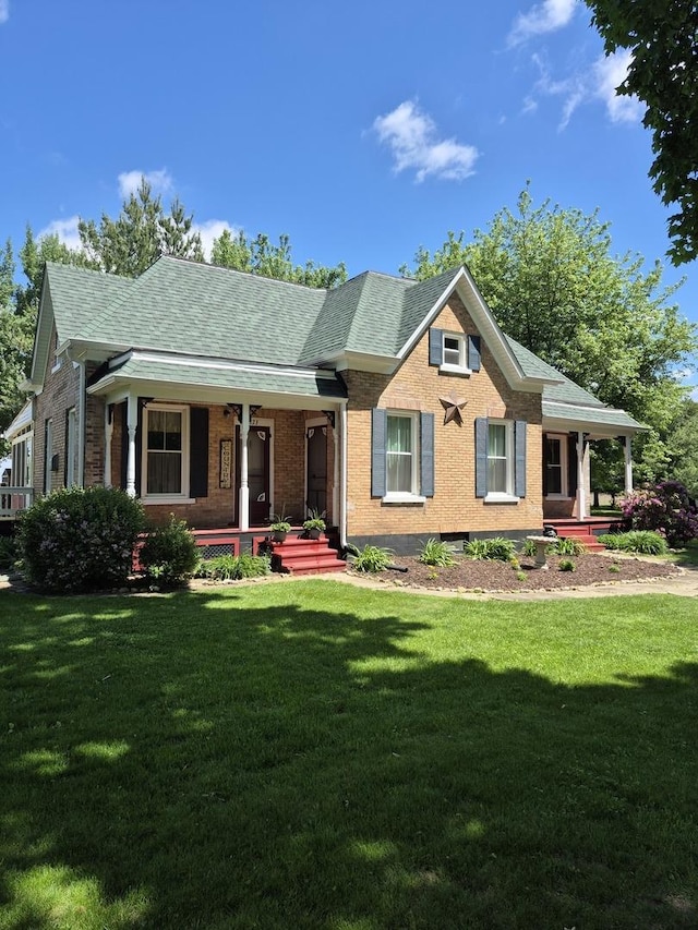 123 W Maple St, Franklin Grove, IL 61031 - view of front of house with a porch, brick siding, a front yard, and roof with shingles