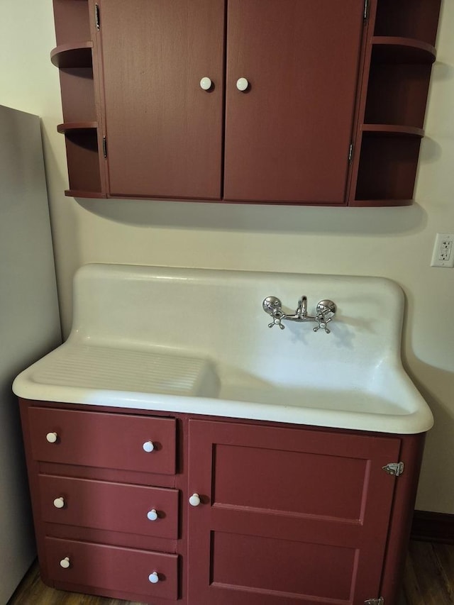123 W Maple St, Franklin Grove, IL 61031 - detailed view of wood finished floors, vanity, freestanding refrigerator, and baseboards