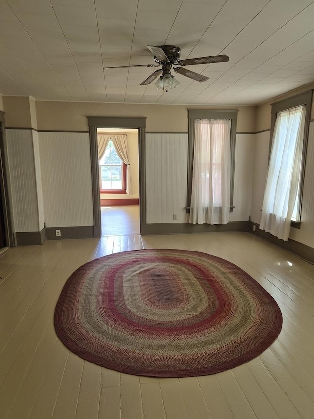 123 W Maple St, Franklin Grove, IL 61031 - unfurnished room with hardwood / wood-style floors, a ceiling fan, and baseboards