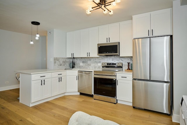 6300 N Sheridan Rd Unit 112, Chicago, IL 60660 - kitchen with stainless steel appliances, decorative backsplash, a peninsula, white cabinetry, and light countertops