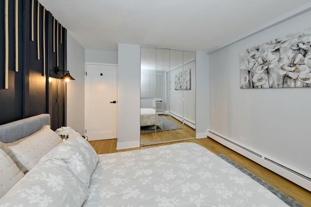 6300 N Sheridan Rd Unit 112, Chicago, IL 60660 - bedroom with baseboard heating, wood finished floors, a closet, and baseboards