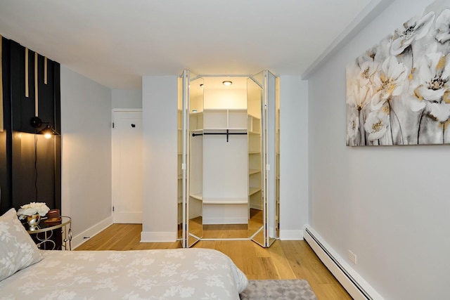 6300 N Sheridan Rd Unit 112, Chicago, IL 60660 - bedroom with a baseboard heating unit, wood finished floors, a closet, and baseboards