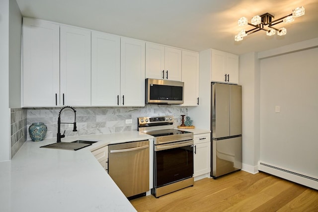 6300 N Sheridan Rd Unit 112, Chicago, IL 60660 - kitchen featuring appliances with stainless steel finishes, a sink, baseboard heating, and light countertops