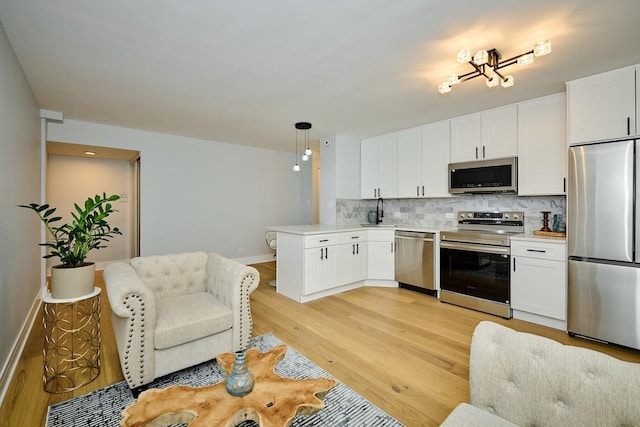 6300 N Sheridan Rd Unit 112, Chicago, IL 60660 - kitchen with stainless steel appliances, a sink, light wood finished floors, tasteful backsplash, and white cabinetry