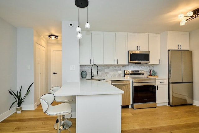 6300 N Sheridan Rd Unit 112, Chicago, IL 60660 - kitchen with appliances with stainless steel finishes, a sink, light wood-type flooring, backsplash, and white cabinetry