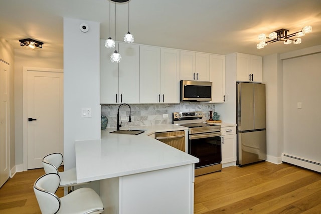 6300 N Sheridan Rd Unit 112, Chicago, IL 60660 - kitchen with appliances with stainless steel finishes, a sink, a kitchen bar, light wood finished floors, and light countertops