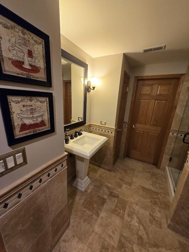 10880 Swallow Tail Ln, Frankfort, IL 60423 - bathroom with a shower stall, a wainscoted wall, and tile walls