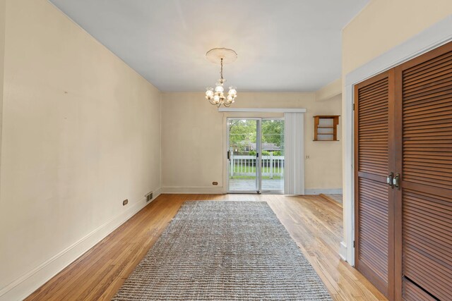 506 Carleton Ave, Glen Ellyn, IL 60137 - unfurnished dining area featuring a chandelier, light wood-style flooring, and baseboards