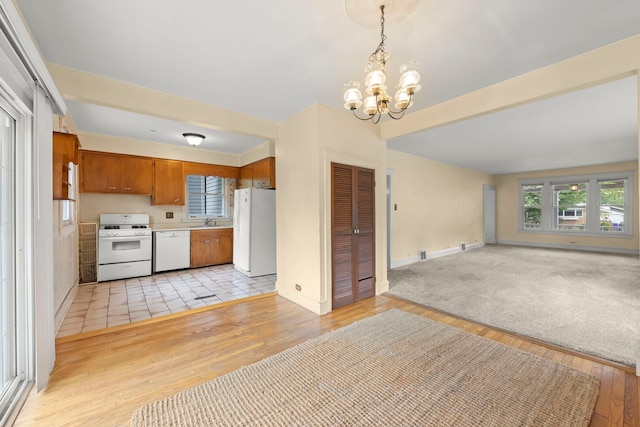 506 Carleton Ave, Glen Ellyn, IL 60137 - kitchen with white appliances, open floor plan, a sink, a chandelier, and brown cabinetry