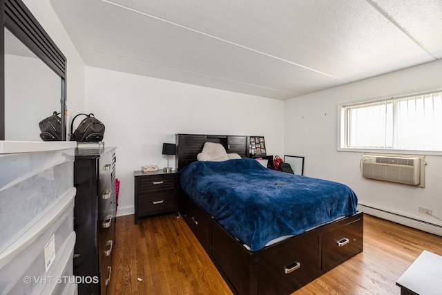 914 N Austin Blvd Unit B10, Oak Park, IL 60302 - bedroom with a baseboard heating unit, dark wood-type flooring, a wall mounted AC, and baseboards