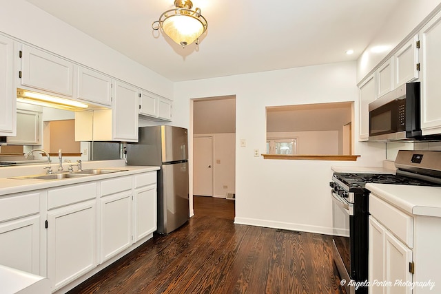 33978 N Lake Rd, Grayslake, IL 60030 - kitchen featuring stainless steel appliances, a sink, dark wood-style flooring, light countertops, and white cabinetry