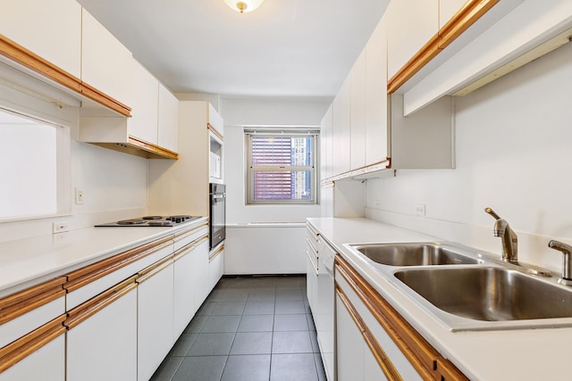 535 N Michigan Ave Unit 1009, Chicago, IL 60611 - kitchen featuring a sink, oven, white cabinets, light countertops, and dark tile patterned floors