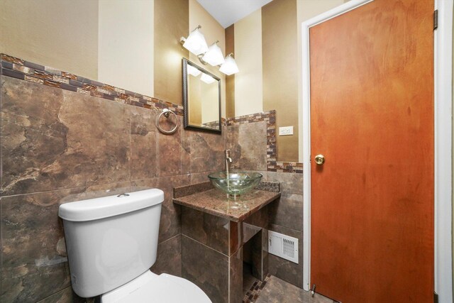 975 Patriot Ln, Hoffman Estates, IL 60192 - half bath with tile walls, a sink, toilet, and wainscoting