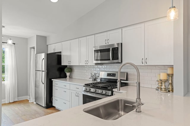 1802 77th St, Naperville, IL 60565 - kitchen featuring appliances with stainless steel finishes, a sink, white cabinets, pendant lighting, and tasteful backsplash
