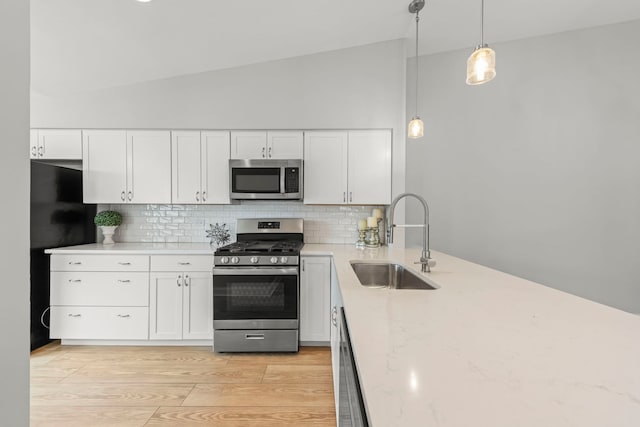 1802 77th St, Naperville, IL 60565 - kitchen with stainless steel appliances, a sink, backsplash, white cabinetry, and high vaulted ceiling