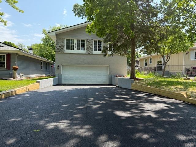 1525 Grove Dr, Round Lake Beach, IL 60073 - view of front of property featuring asphalt driveway, an attached garage, and stone siding